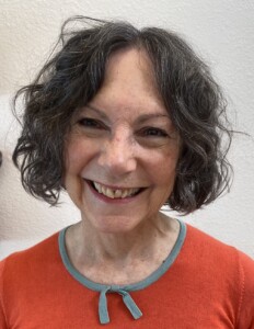 Photograph of Suzanne in an orange sweater